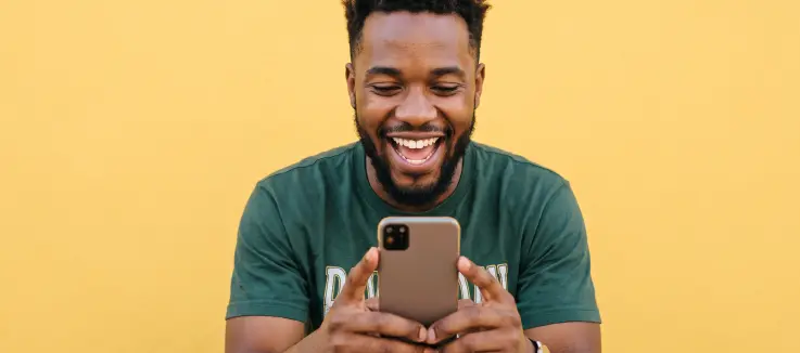 Black guy excitedly playing a crash game on his phone