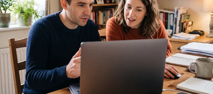 woman and man examining laptop screen 