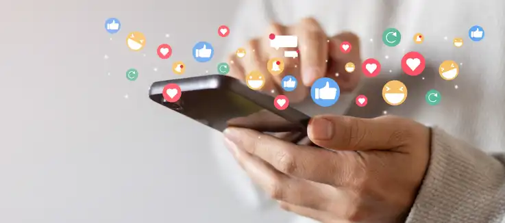 man holding a cell phone with social media icons popping out of it.