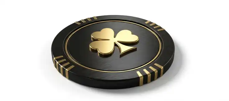 a black and gold casino chip with a clover leaf on it