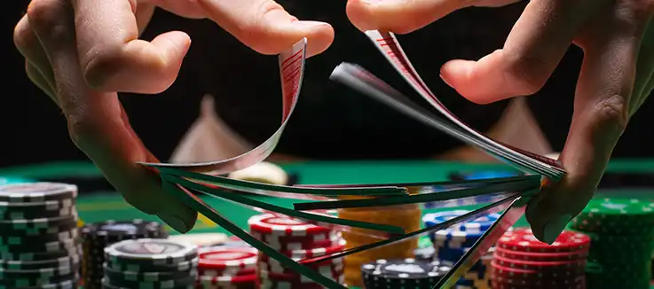 casino dealer shuffling the cards at a poker table